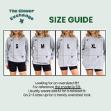 A size guide graphic for The Clover Exchange showing four models wearing light gray oversized hoodies in sizes S, M, L, and XL, with measurement lines and text explaining fit guidance.