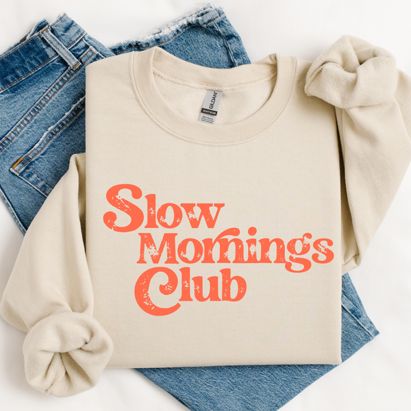 Beige sweatshirt with 'Slow Mornings Club' text on a white background