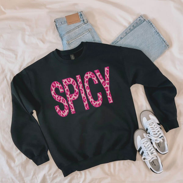 Black Spicy leopard print sweatshirt laid flat with jeans and white sneakers