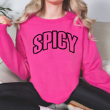 Person wearing a pink sweatshirt with 'SPICY' text, sitting on a couch.