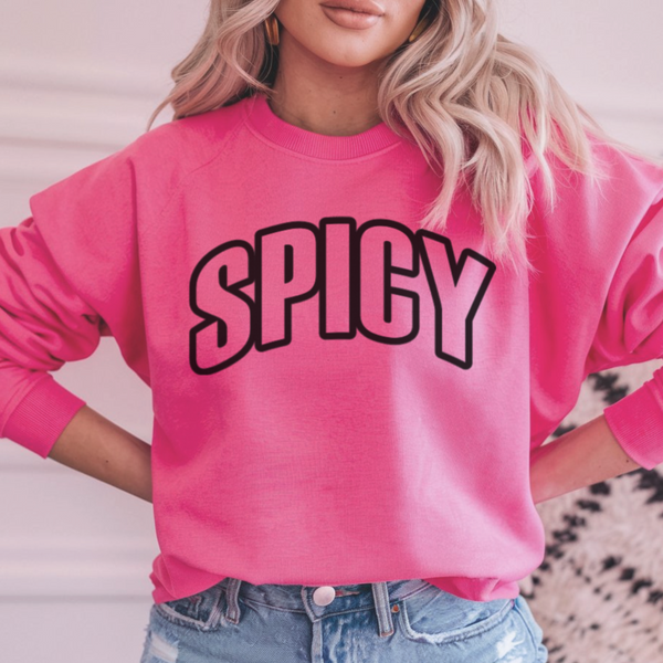 Person wearing a pink sweatshirt with 'SPICY' text, standing against a neutral background.