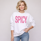 Person wearing a white sweatshirt with 'SPICY' in pink leopard print on a plain background