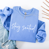 Blue sweatshirt with 'stay seated' text on a white background