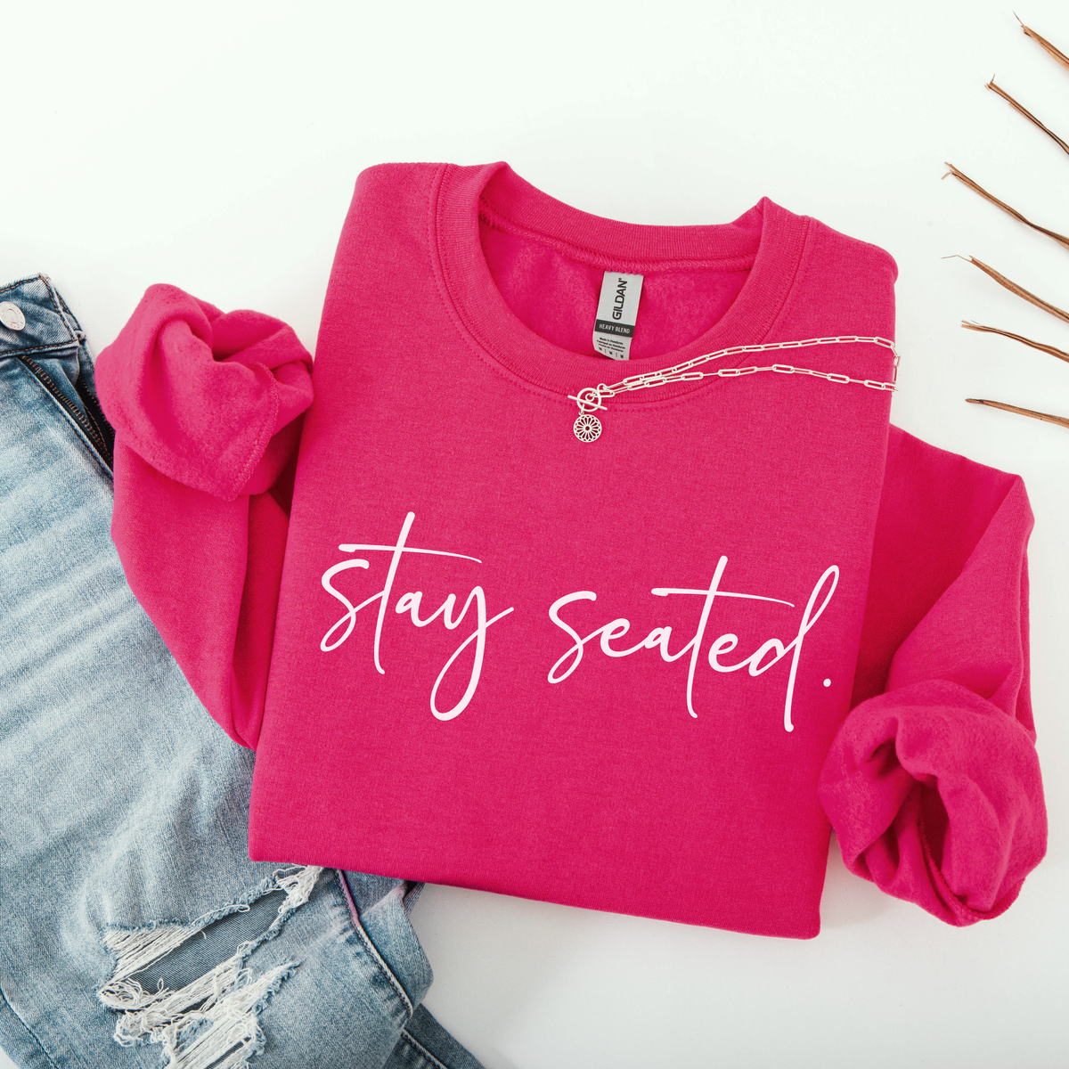 Pink sweatshirt with 'stay seated' text on a white background