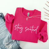 Pink sweatshirt with 'stay seated' text on a white background
