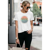 Woman wearing a white t-shirt with a colorful graphic design that says 