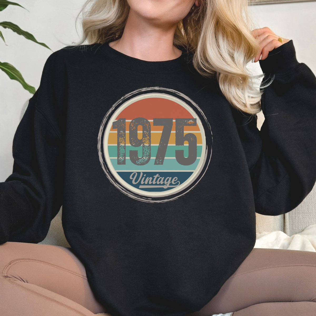 Person wearing a black sweatshirt with '1975 Vintage' design.