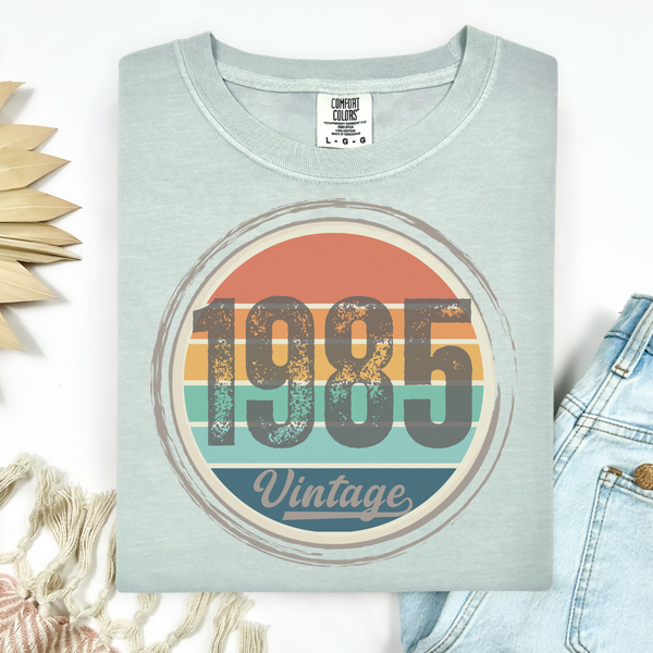 Light green Comfort Colors T-shirt with '1985 Vintage' design on a white background