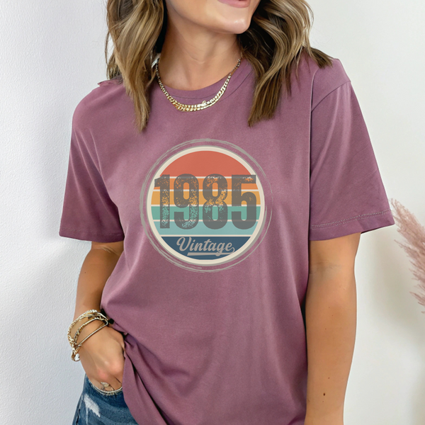 Person wearing a purple t-shirt with '1985 Vintage' design on a plain background