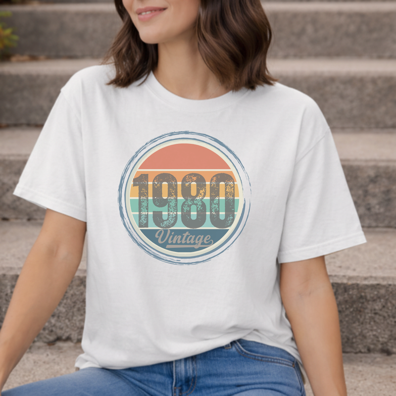 A woman wearing a white t-shirt with '1980 Vintage' design sitting on steps.