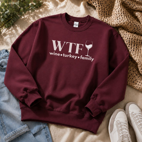 A maroon sweatshirt that reads "WTF Wine Turkey Family" and an outline of a wine glass