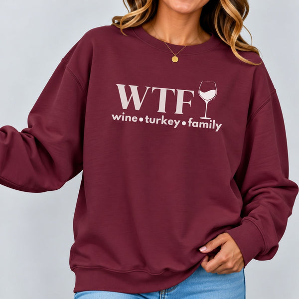 A woman wearing maroon sweatshirt that reads "WTF Wine Turkey Family" and an outline of a wine glass