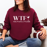 Person wearing a maroon sweatshirt with 'WTF wine turkey family' text, holding a football.