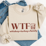 Beige sweatshirt with 'WTF whiskey turkey family' text on a white background over a pair of jeans