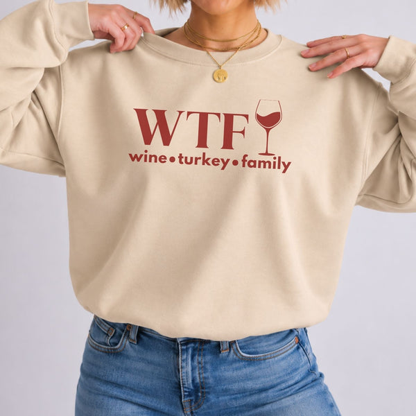 A sand colored sweatshirt that reads "WTF Wine Turkey Family" and an outline of a wine glass