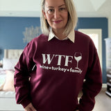 A woman standing in a maroon sweatshirt that reads 
