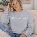 A woman wearing a light gray sweatshirt with 