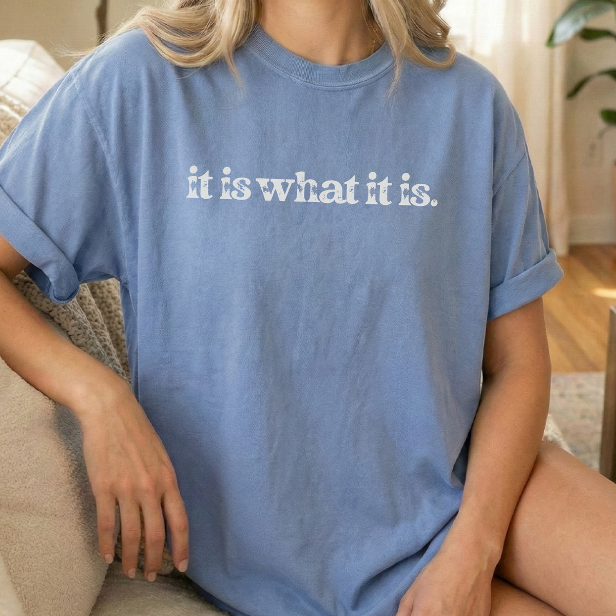 Person wearing a blue t-shirt with 'it is what it is' text.