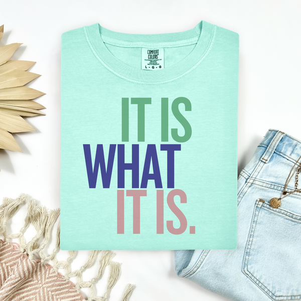 Mint green t-shirt with 'IT IS WHAT IT IS' text on a white background