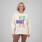 Woman wearing a cream sweatshirt with colorful text that reads 