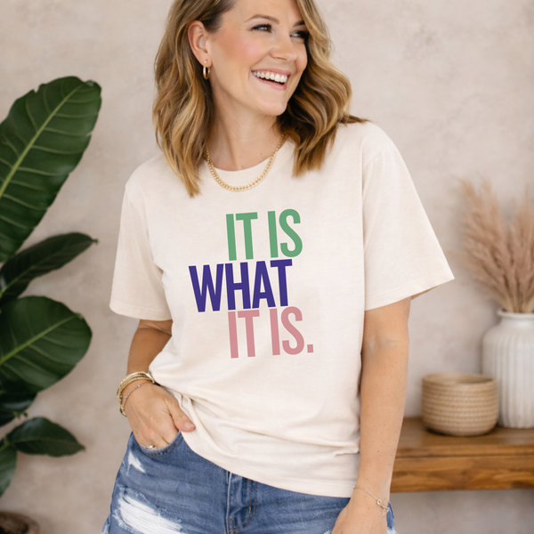 Woman wearing a t-shirt with colorful text in a home setting