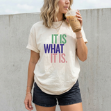 A woman wearing a white t-shirt with colorful text that reads 