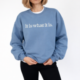 A woman wearing a blue sweatshirt with 