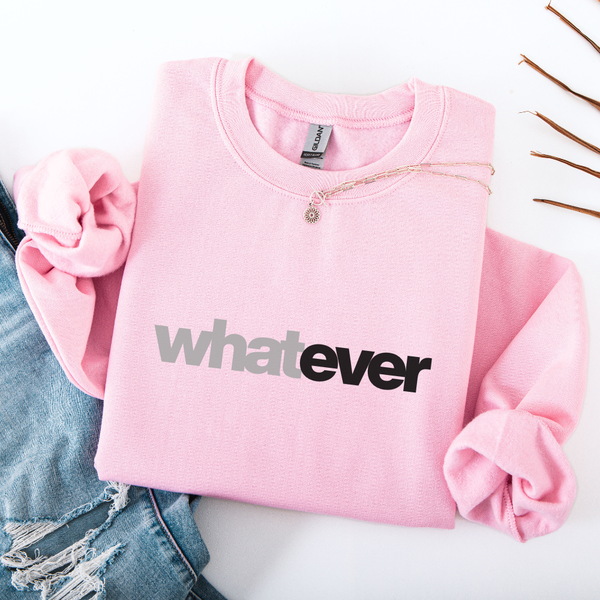 Pink sweatshirt with 'whatever' text on a white surface