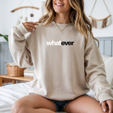 Woman wearing a beige crewneck with 'whatever' text in a casual setting.