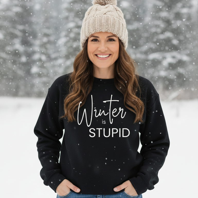 A woman in a Black Winter is Stupid sweatshirt in a snowy setting