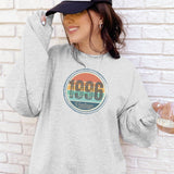 Woman in an ash gray vintage birthday sweatshirt with a retro birth year badge, second view.